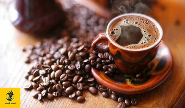 عکس یک فنجان قهوه ای رنگ قهوه که در اطراف ان دانه های قهوه ریخته شده است.- ژن سبز