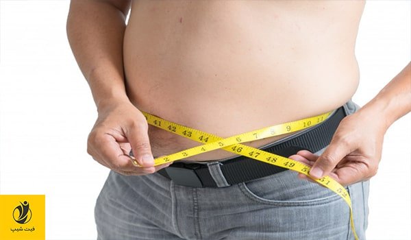 عکس مردی که با یک متر زرد رنگ دور شکمش را اندازه می گیرد تا ببینید سندرم متابولیک دارد یا نه - ژن سبز